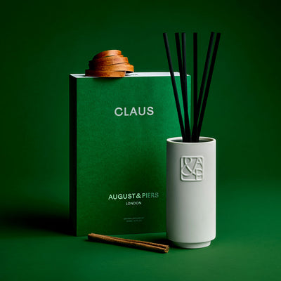 AUGUST&PIERS CLAUS luxury diffuser in white ceramic vessel with green packaging – festive home fragrance with pine and cinnamon notes.