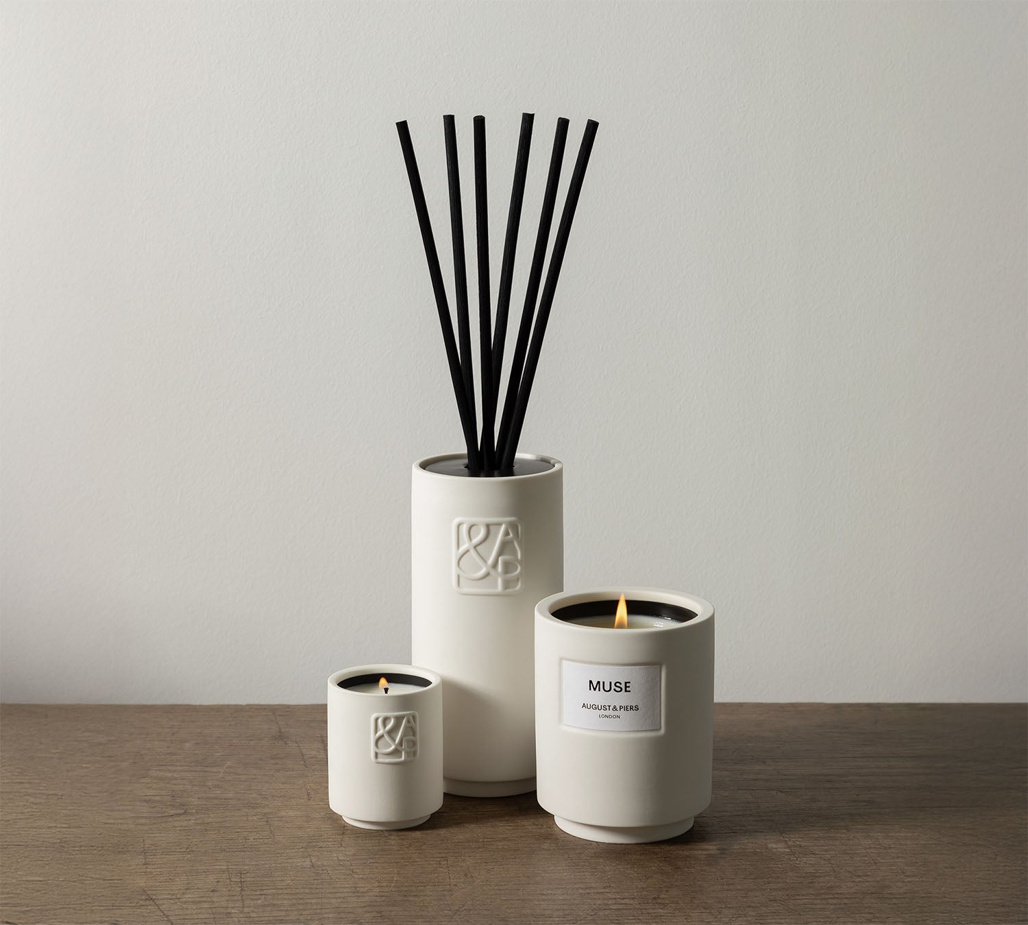 AUGUST&PIERS MUSE candle and diffuser set – luxury home fragrance in white ceramic vessels with black reeds.