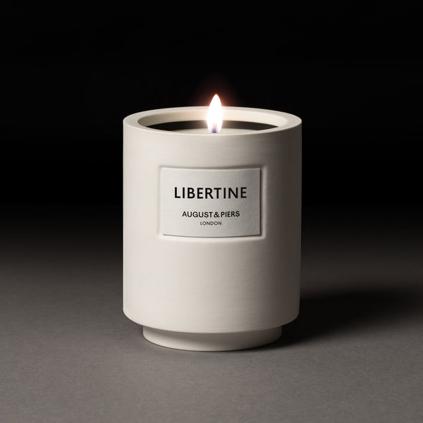 AUGUST&PIERS 340g Libertine scented candle with fragrance notes of cedarwood, patchouli and guaiac wood in white ceramic vessel.