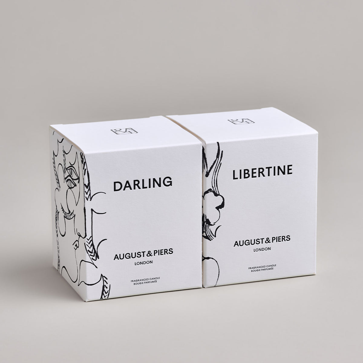 The Iconic Duo Gift Set by AUGUST&PIERS London. This set features the Darling and Libertine scented candles in limited-edition dark gold packaging.