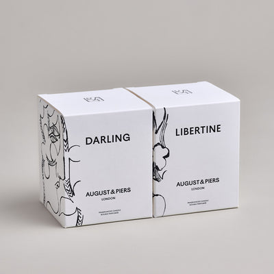 The Iconic Duo Gift Set by AUGUST&PIERS London. This set features the Darling and Libertine scented candles in limited-edition dark gold packaging.