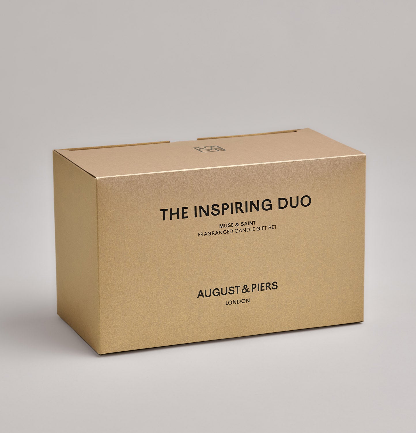 The Inspiring Duo Gift Set by AUGUST&PIERS London. This set features the Muse and Saint candles in limited-edition light gold packaging.