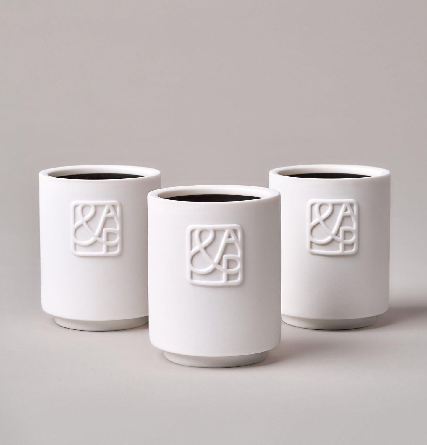 AUGUST&PIERS 90g white ceramic candles with embossed 'A&P' logos on the front, displayed on a neutral background.